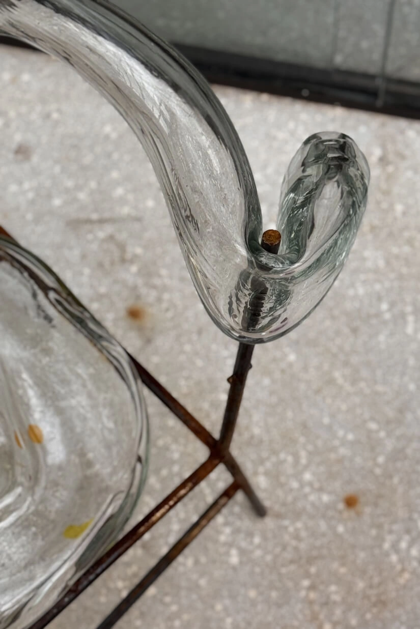 Curva de vidro transparente presa a haste de ferro